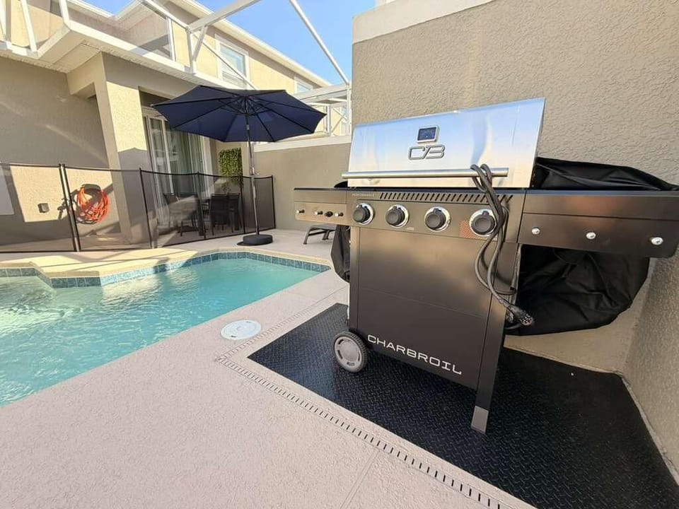 Poolside patio with grill and shaded lounge area for relaxing gatherings