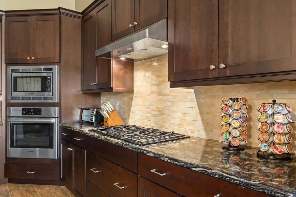 Gourmet kitchen with rich cabinetry and stainless appliances including double wall ovens.  Professional-grade gas range. Coffee bar fully stocked. All cookware included.