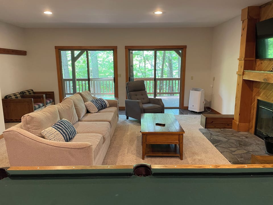 lower level rec room with wood-burning fireplace, TV, and pool table