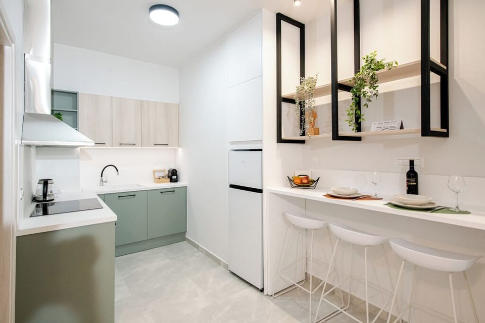 A sleek kitchen with minimalist cabinetry, pendant lighting, and bar dining.
