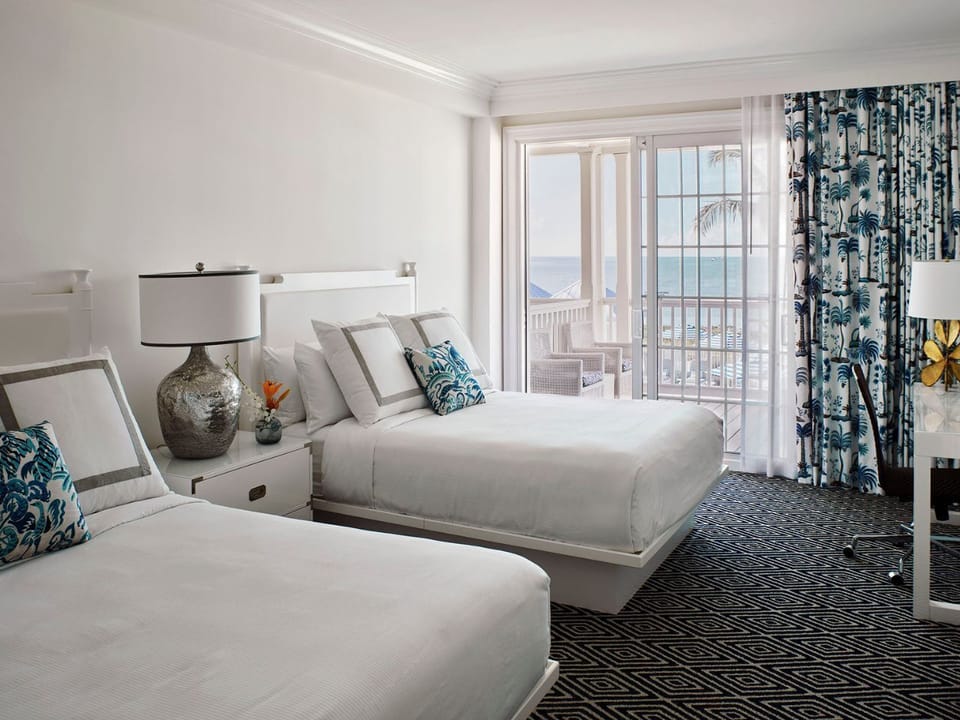 Bright and airy bedroom with soft accents and large windows overlooking serene views.