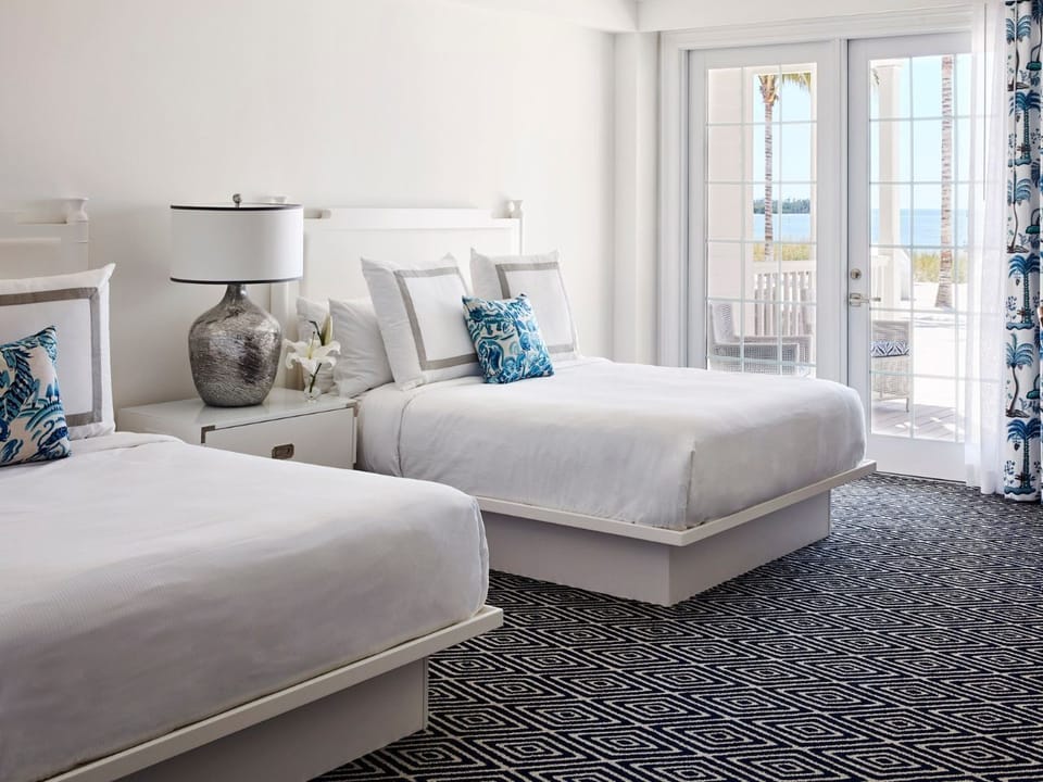 Bright and airy bedroom with plush bedding and a private balcony, perfect for peaceful mornings.