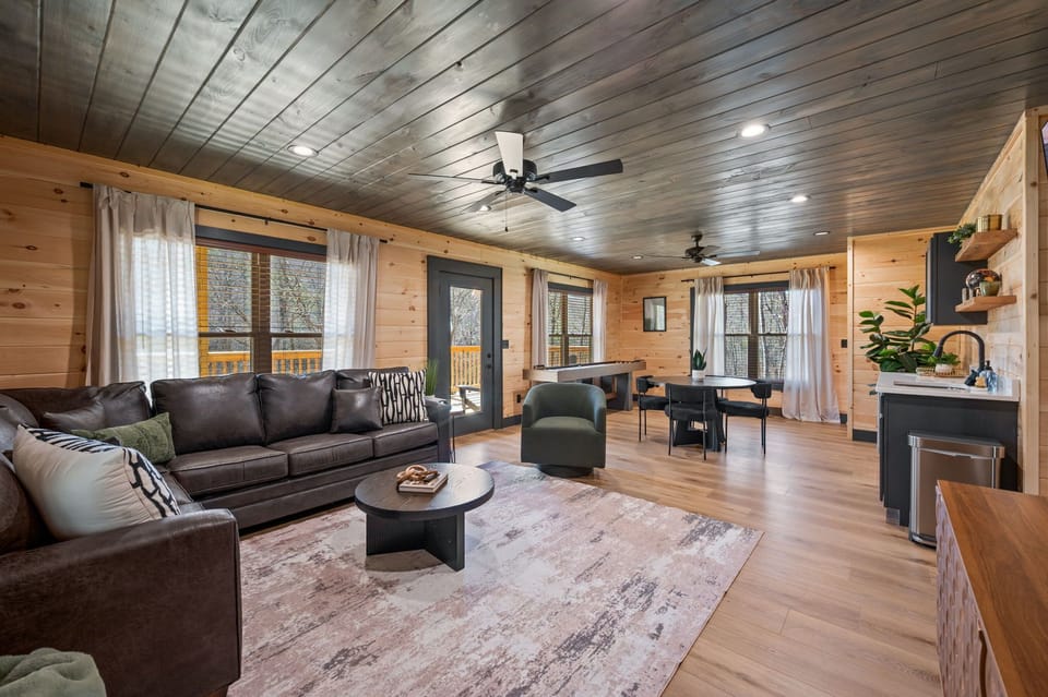 Lower level living room with queen pullout sofa, TV, shuffleboard, and bar.