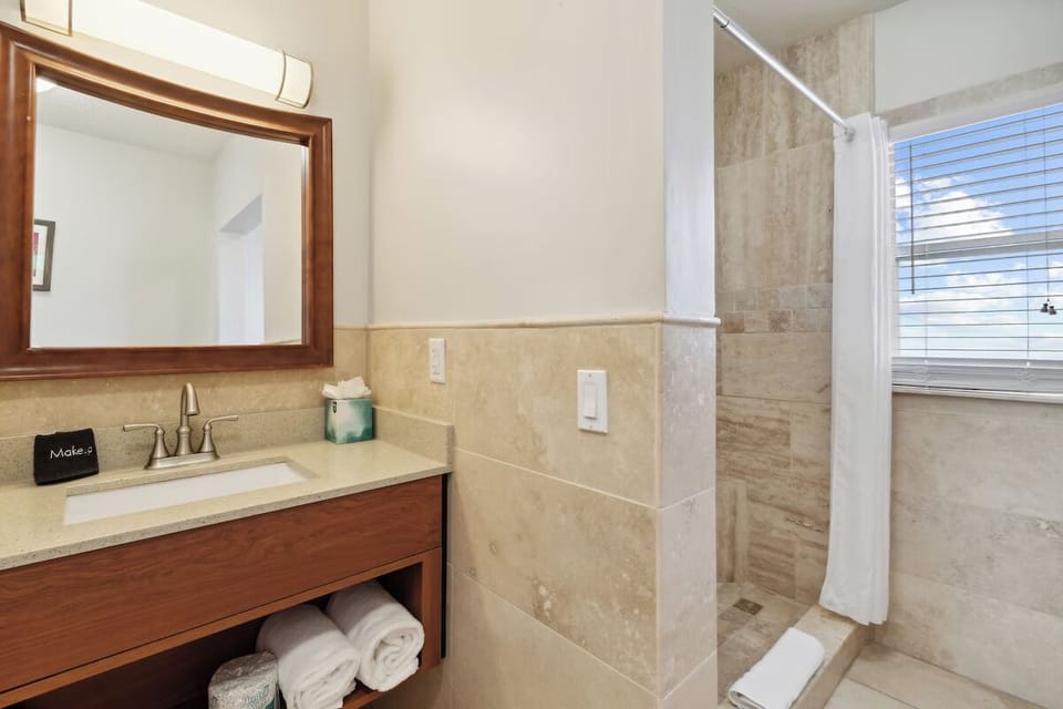 Refresh under warm lighting with spa-like tiled shower.