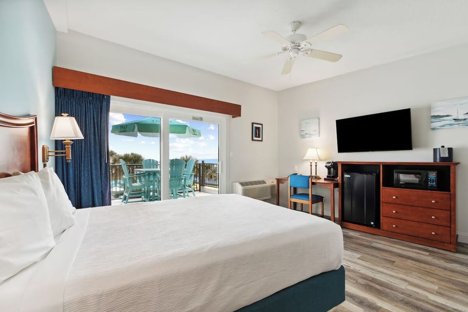 Unwind in a bright bedroom with breezy balcony views.