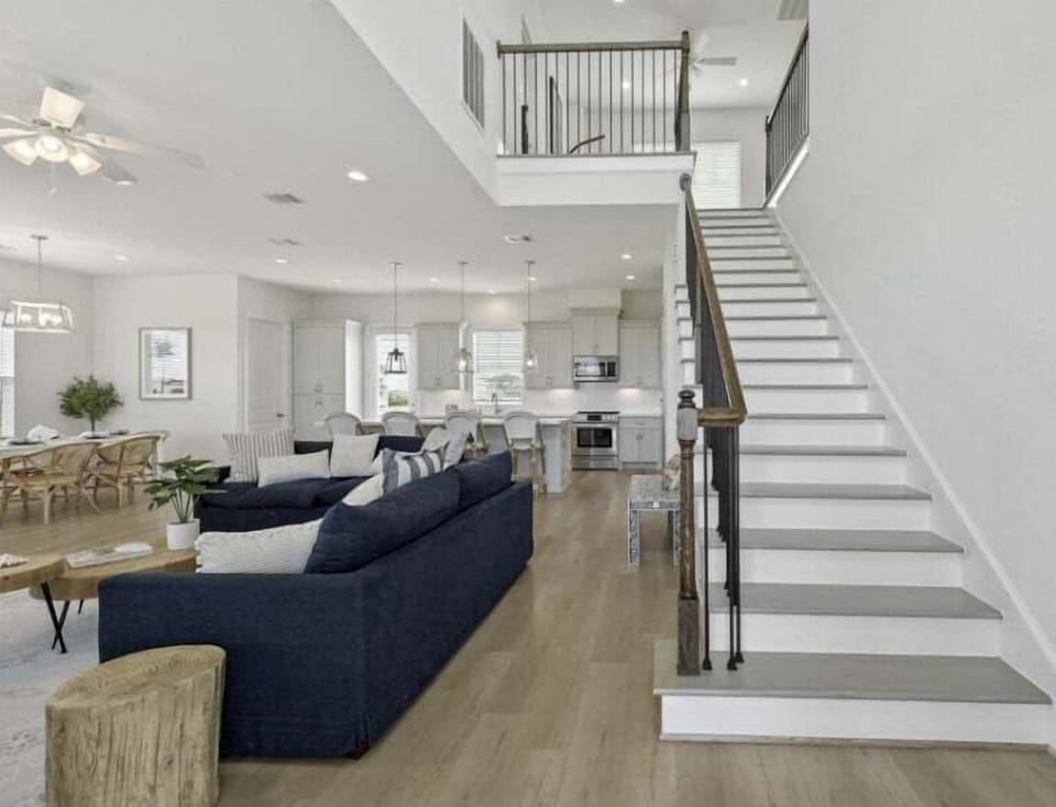 Open living and dining space with staircase and modern coastal finishes—ideal for group stays in Galveston.