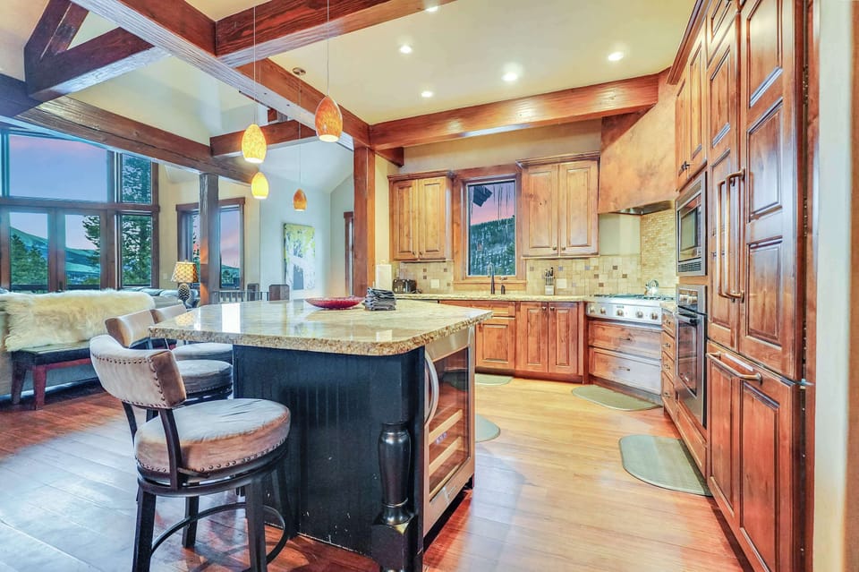 Large Chef inspired kitchen with gas stove, wine refrigerator, and expansive counter space.