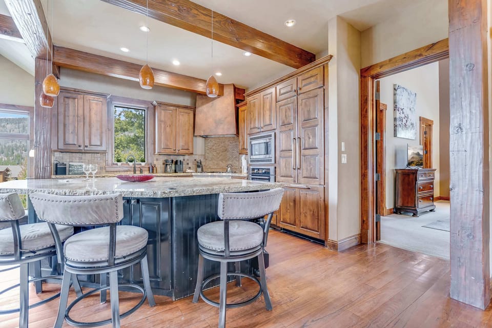 Large Chef inspired kitchen with gas stove, wine refrigerator, and expansive counter space.