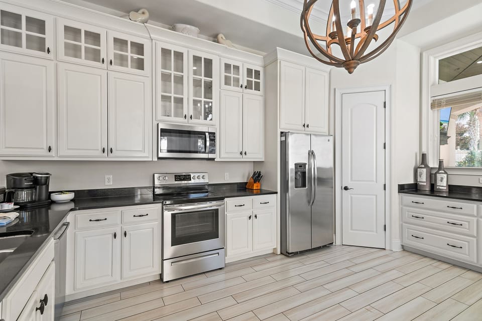GOURMET, FULLY-STOCKED KITCHEN: Cook in style with upscale appliances, custom cabinetry, and a marble-topped entertainment bar, all with Pool and Hot Tub Views!