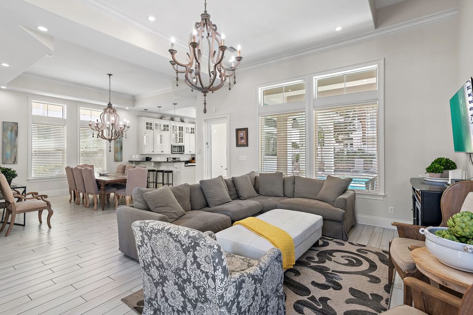 Large, Open Living Space with vaulted ceilings and plenty of comfortable seating around a 65" Smart TV overlooking the your very own backyard Oasis!