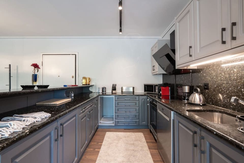 Kitchen detail — marble countertops, Nespresso machine, full knife set and premium cookware. Ready for stays of any length. Booking.com tag: Kitchen or kitchenette