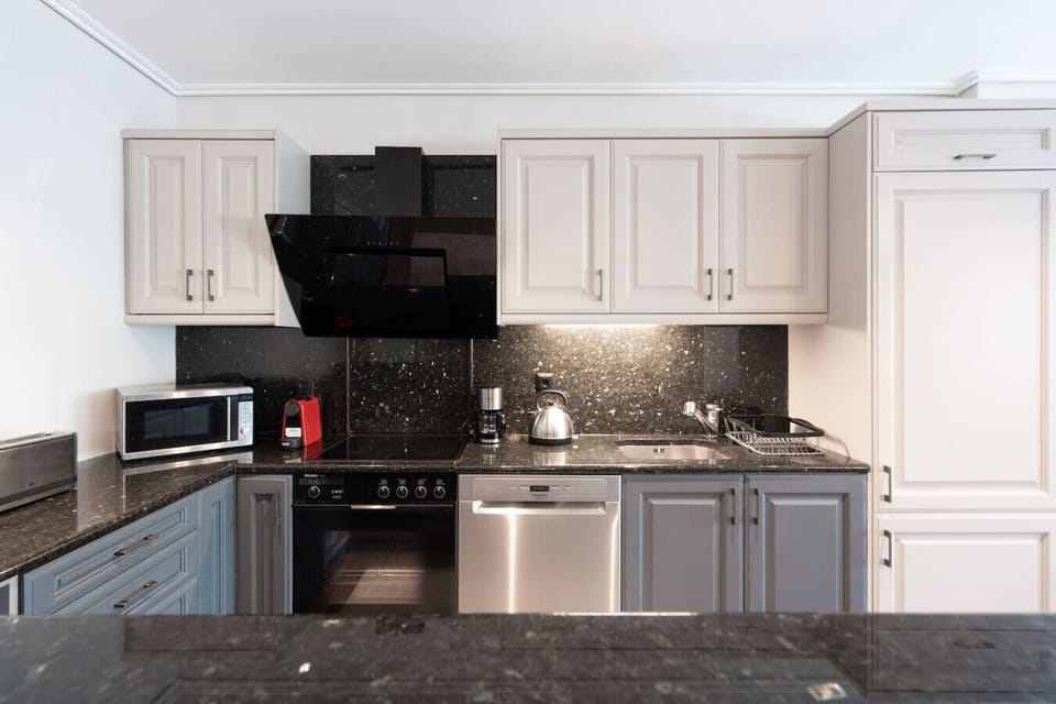 A fully-equipped designer kitchen — espresso machine, full oven, dishwasher, and everything you need for cooking in or hosting. Booking.com tag: Kitchen or kitchenette