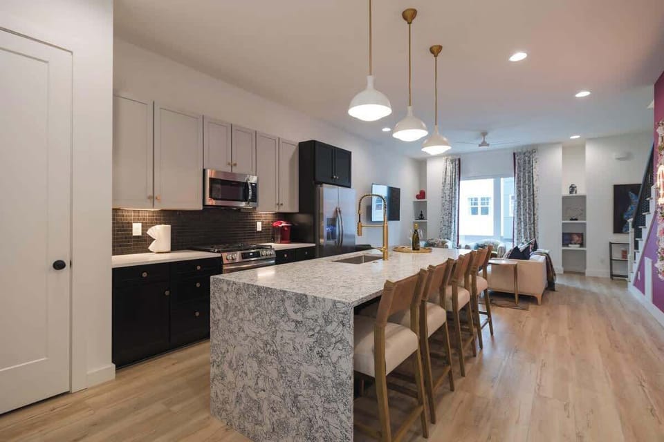 Modern kitchen with a large island and open living area.