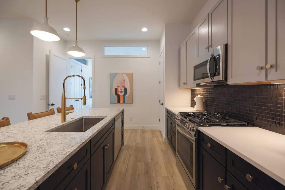 Modern kitchen with sleek finishes and gold accents.