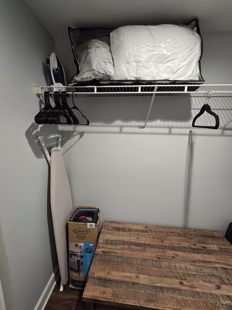 Primary walk in closet with hangers, iron/board, pack n play