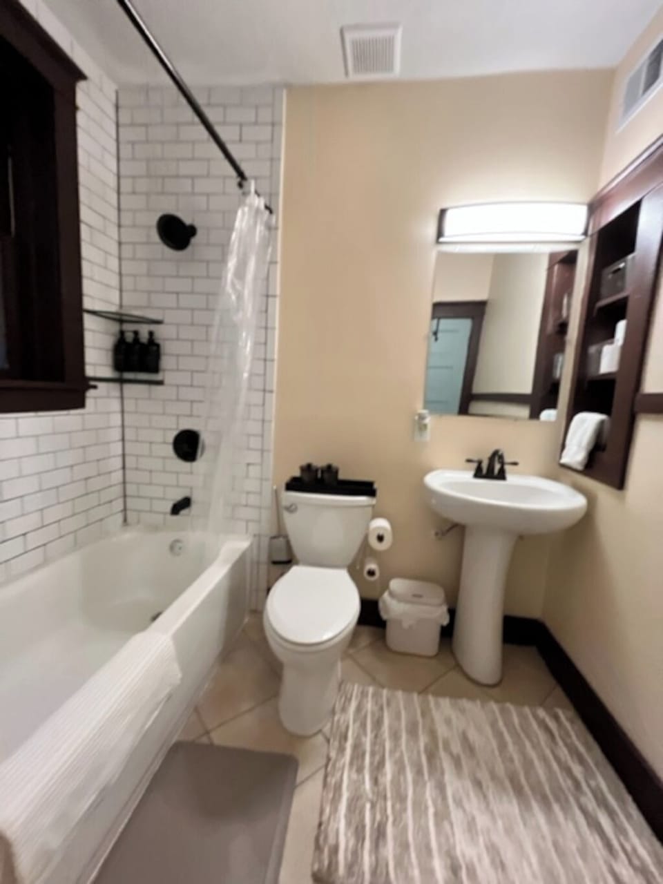 Our bathroom includes a tiled shower surround and a pedestal sink.