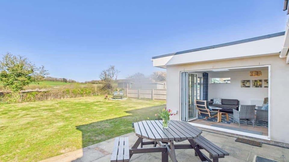 A spacious patio area with outdoor furniture, ideal for alfresco dining and summer BBQs.