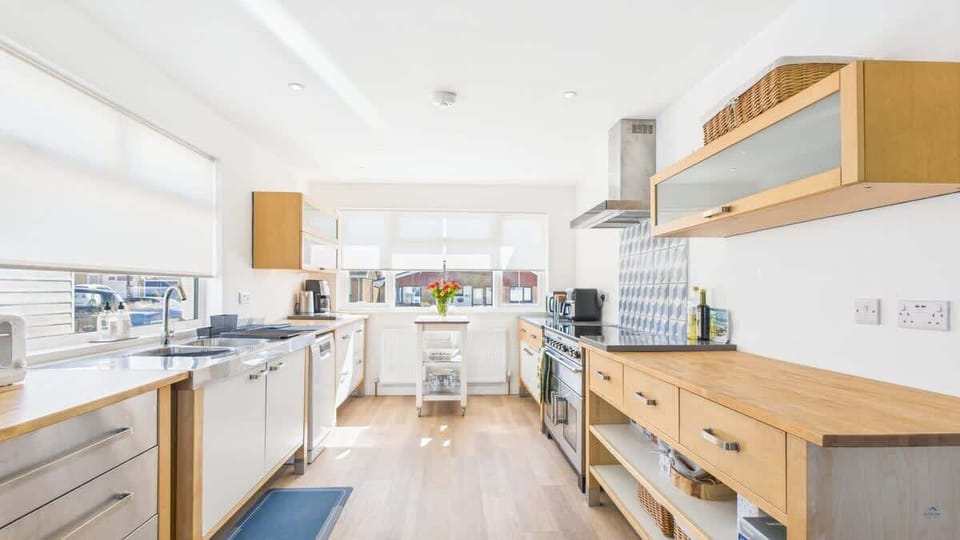 A high-spec luxury kitchen featuring a central island, induction hob, and integrated appliances.