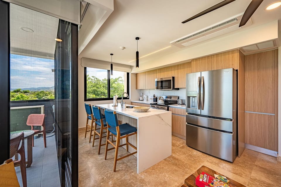 Large kitchen area with breakfast counter with panoramic ocean and sunset view