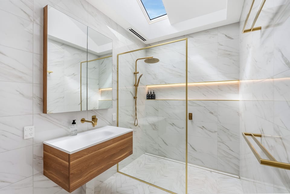 Elegant Gold Accents with Skylit Shower