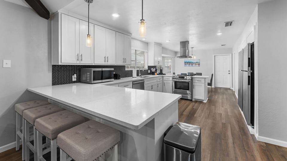 Step into your dream kitchen! ✨ With sleek white cabinets and a spacious countertop, this beautifully designed space is perfect for whipping up delicious meals. Enjoy modern appliances and a warm ambiance that will make every meal feel special! 🏠🍳