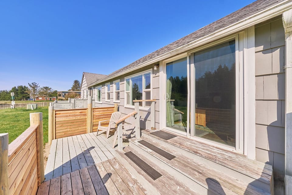 Back view of the cottage with access to a cozy patio—featuring outdoor seating, perfect for enjoying a quiet moment outdoors.