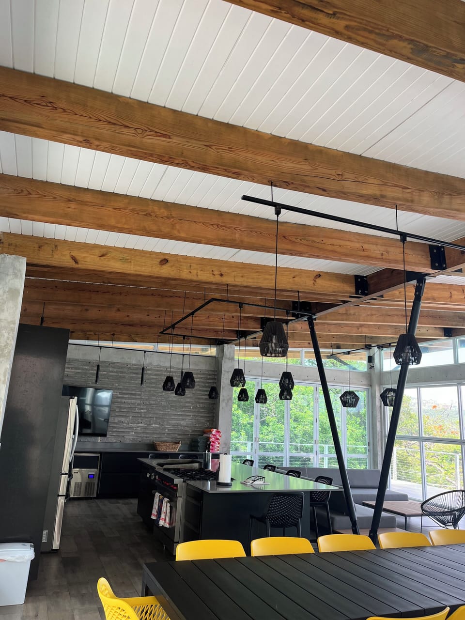Entertainment area with kitchen, dining table, large sofa and rocking chairs.
