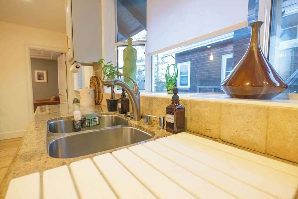 Prep and clean up with ease in this bright kitchen sink area, featuring generous counter space and a window that fills the room with natural light