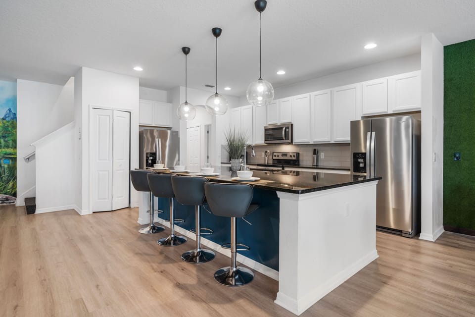 - Modern kitchen with stainless steel appliances and island bar  
- Seating for four at the counter with stylish pendant lighting  
- Fully equipped cooking space for family meals and groups