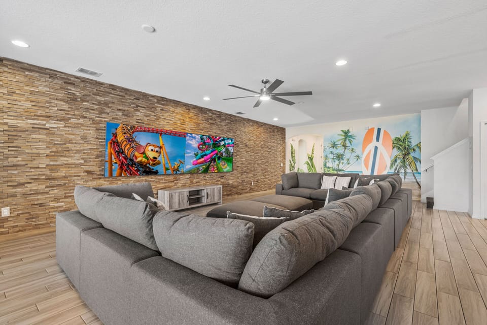- Spacious living room with plush sectional seating for everyone  
- Feature wall with mounted TVs for family movie nights and games  
- Modern vacation rental near Disney designed for comfort