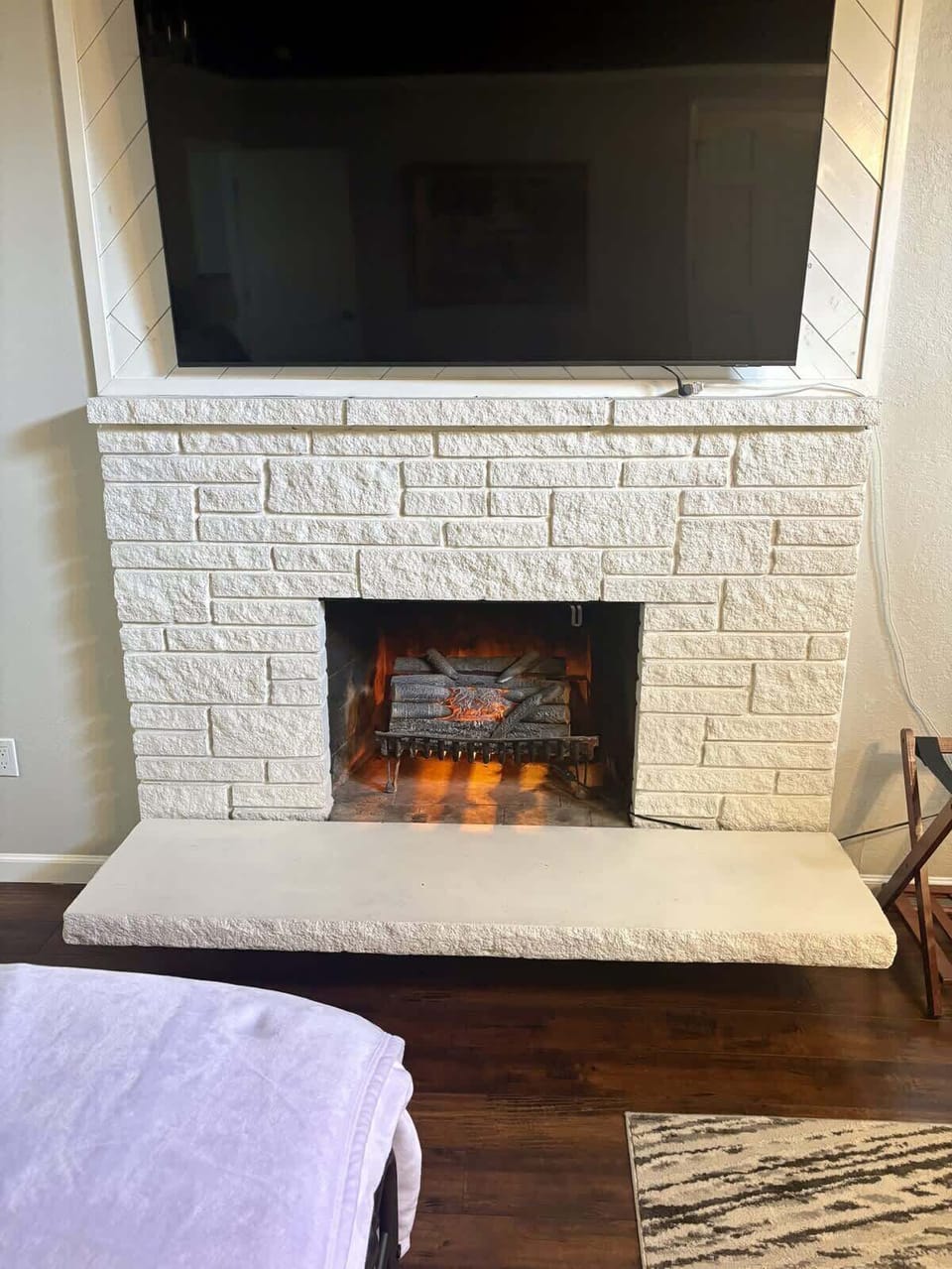 The primary suite includes a large TV and ornamental fireplace for a cozy place to unwind.