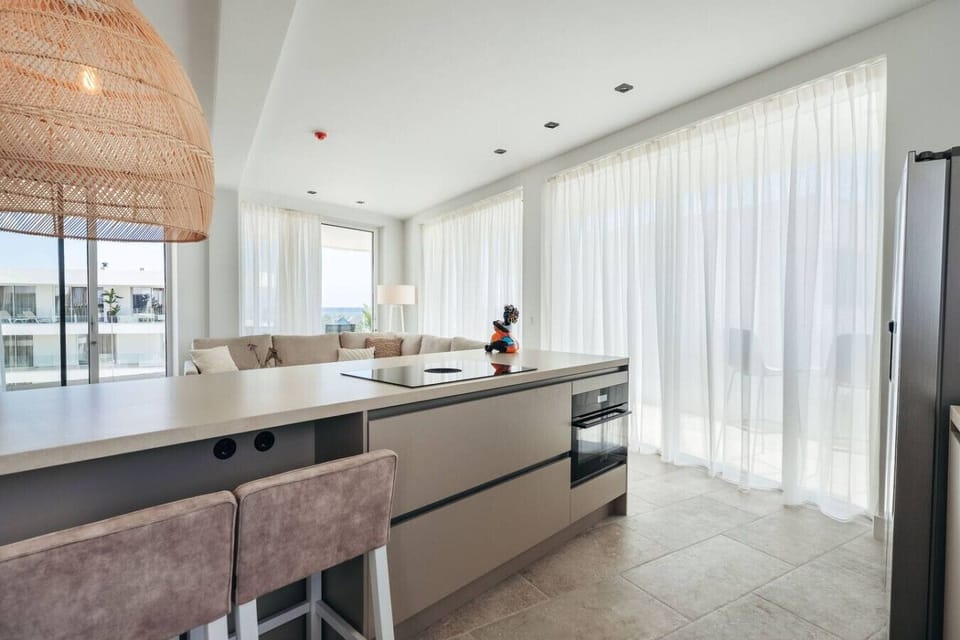 Step into this bright and welcoming kitchen! With its airy vibe and cozy seating, it’s the perfect spot for casual meals and lazy chats.