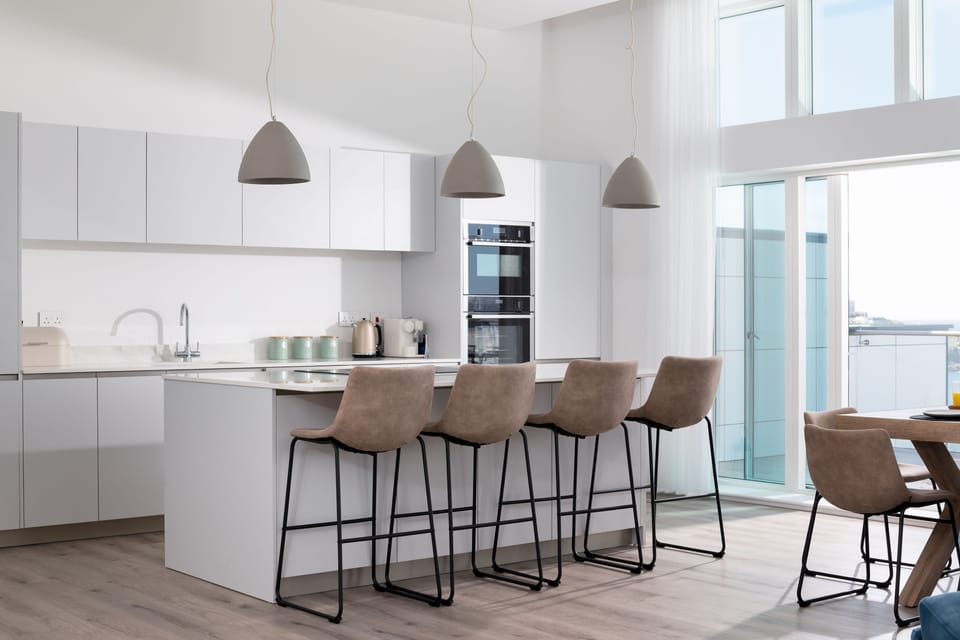 26 Cliff Edge Penthouse, Newquay: The superbly equipped kitchen  features high-quality appliances, including a sleek wine cooler and a stylish breakfast bar with four suede bar stools