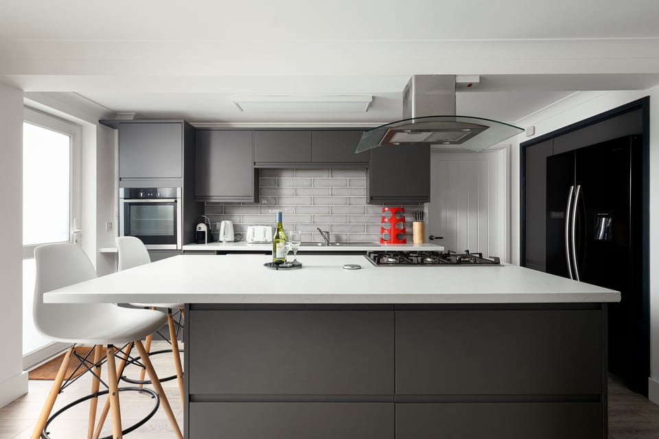 Mermaid Gaze, Newquay: The superbly equipped kitchen features an electric oven and gas hob, fridge/freezer, microwave, dishwasher, and island unit with two stools