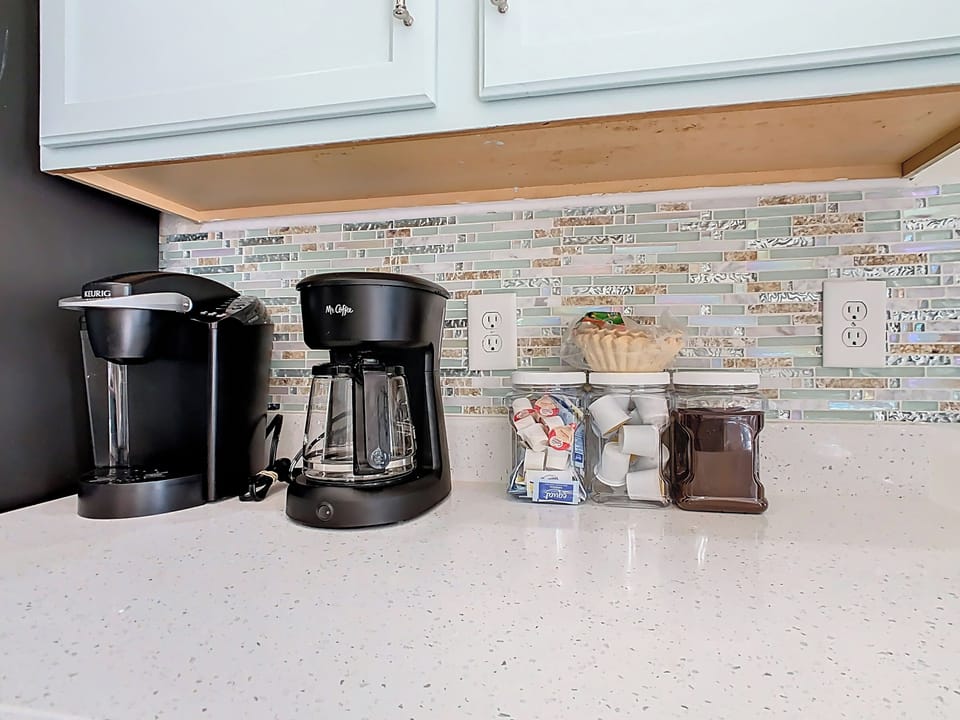 - Start your day right with a Keurig & drip coffee maker plus all your morning fixings
- Enjoy coffee pods, creamers, sweeteners, & filters conveniently stocked for guests
- Sparkling counter & beachy backsplash make your brew station feel extra inviting