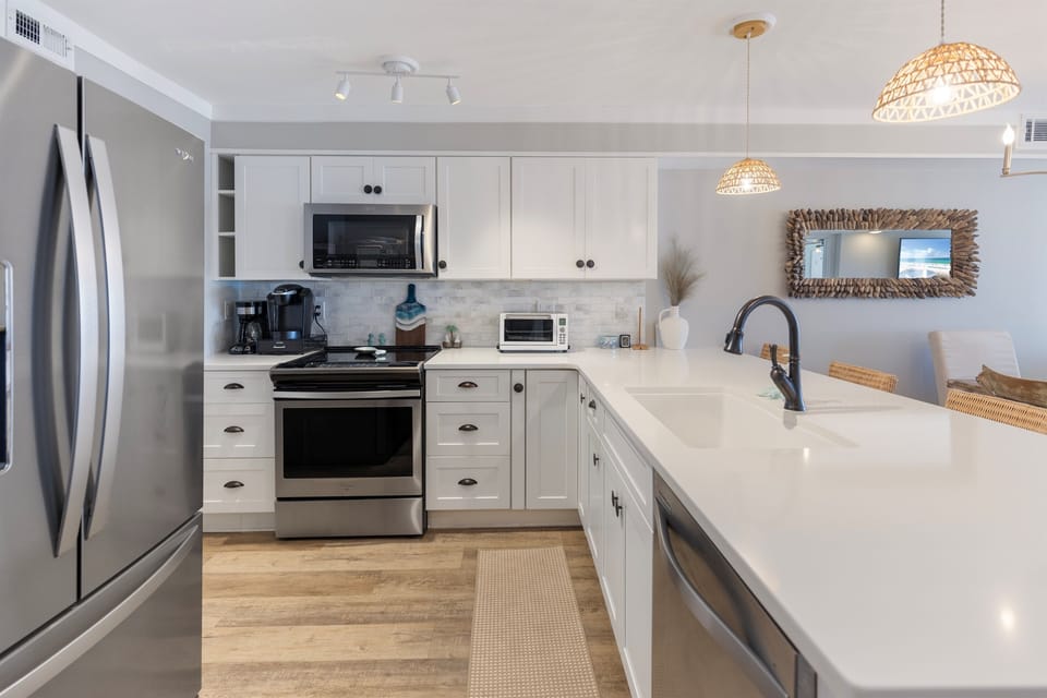 Your fully equipped kitchen awaits with gleaming countertops, modern appliances, and warm coastal touches that make cooking feel like pure joy.