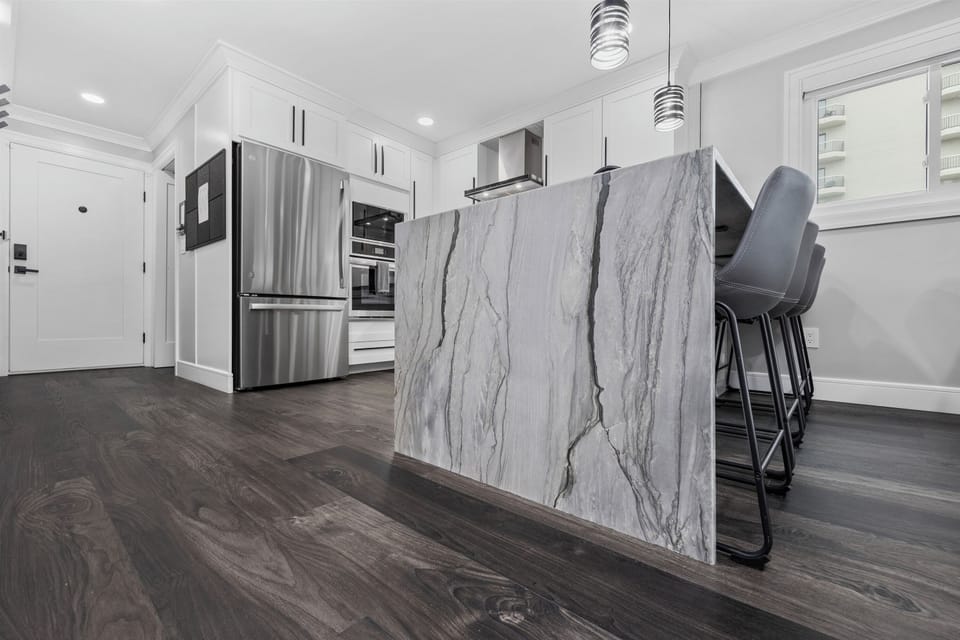 Contemporary chef’s kitchen with a waterfall island and bar seating.