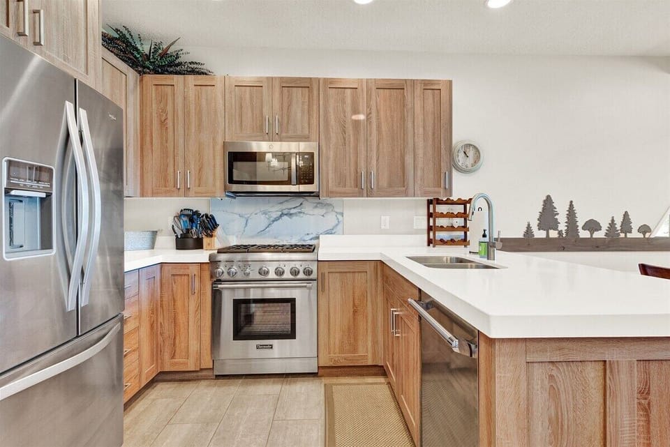 Prepare meals with ease in the bright, well-appointed kitchen featuring stainless steel appliances, generous counter space, and warm wood cabinetry.