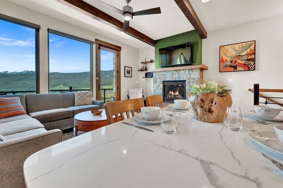 Gather around the dining table for meals, games, or morning coffee while enjoying the fireplace glow and sweeping views of the Ogden Valley.