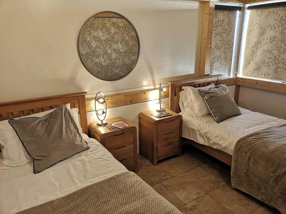 2 single beds, beside cabinets and lamps and large mirror