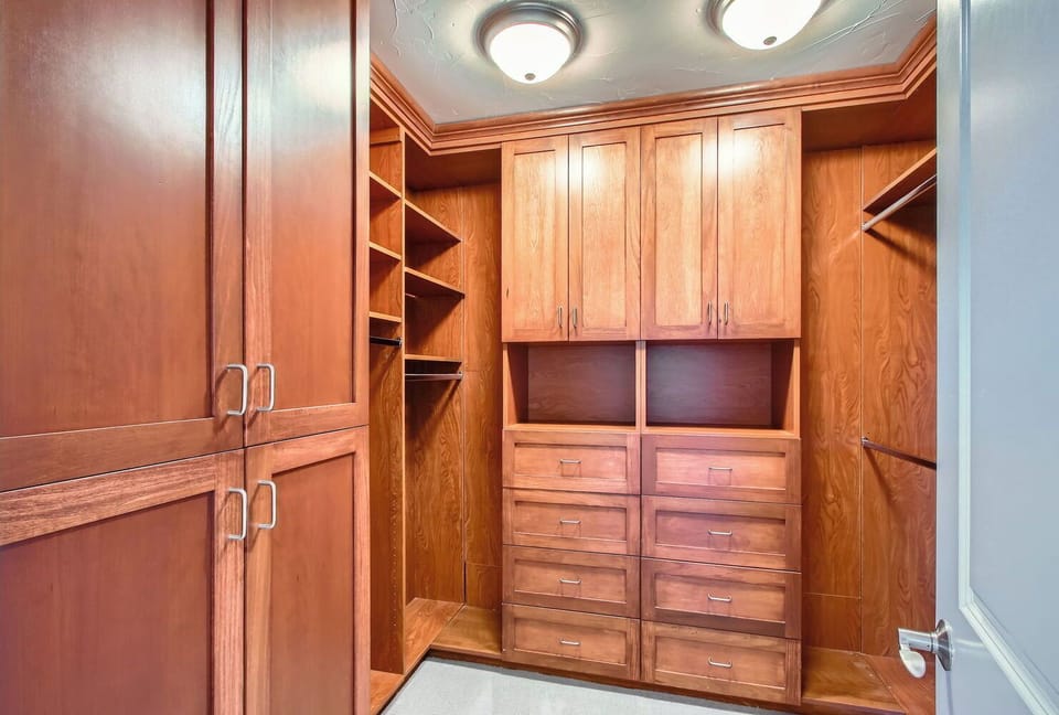 Organized Luxury - A Walk-In Closet with Custom Wood Drawers and Ample Space
