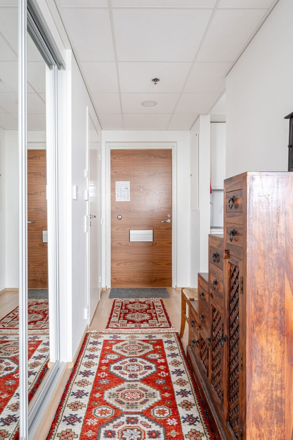The welcoming entryway features mirrored closets and unique wooden accents, offering a stylish first impression of your home away from home.