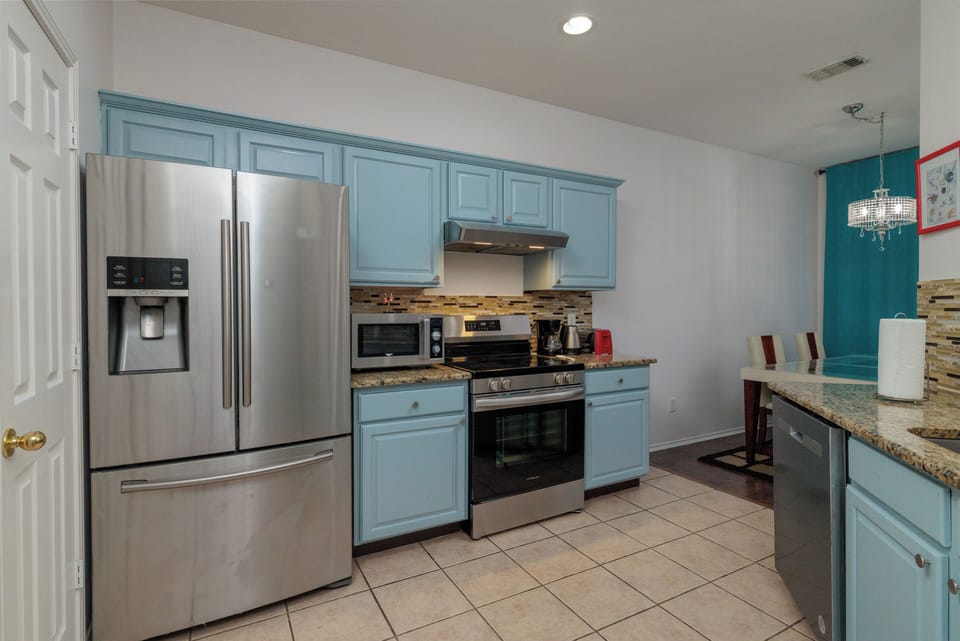 Fully stocked kitchen with fridge, microwave, range, sink and dishwasher.