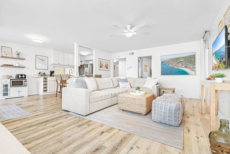 The living room area includes a sofa set and cable TV.
                