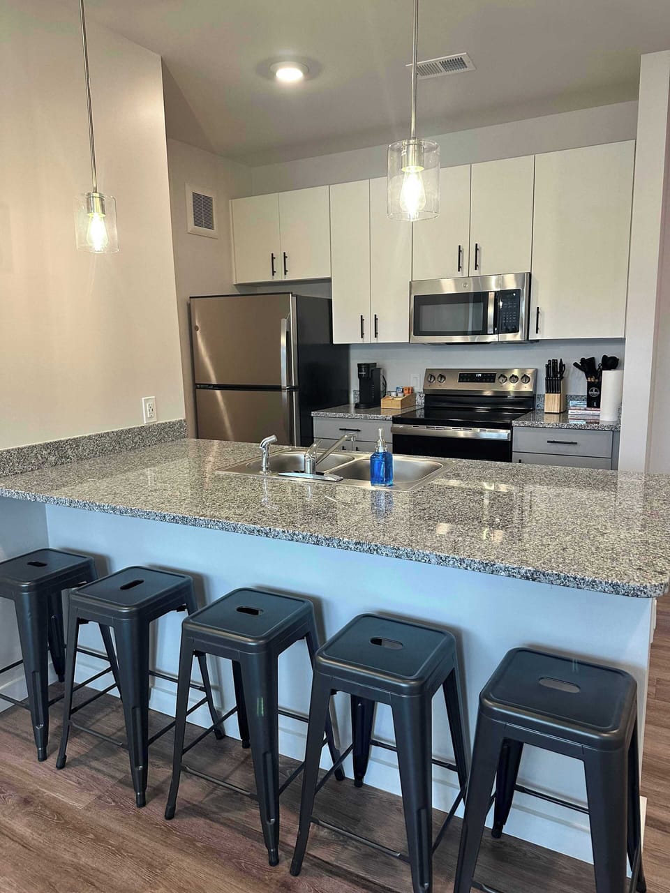 Modern and fully equipped kitchen with stainless steel appliances, granite countertops, and seating for you and your guests—perfect for home-cooked meals or morning coffee!