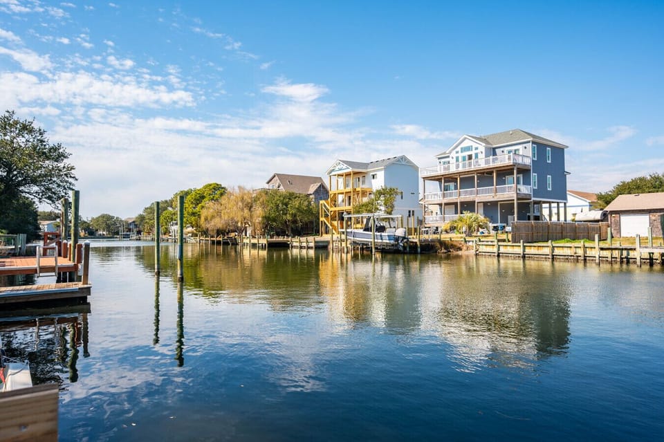 Calm canal view w/ docks and homes lining the water, showcasing the laid-back coastal vibe.