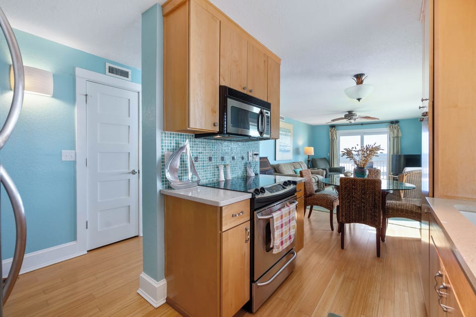 Kitchen stove, oven, microwave looking into the main living area