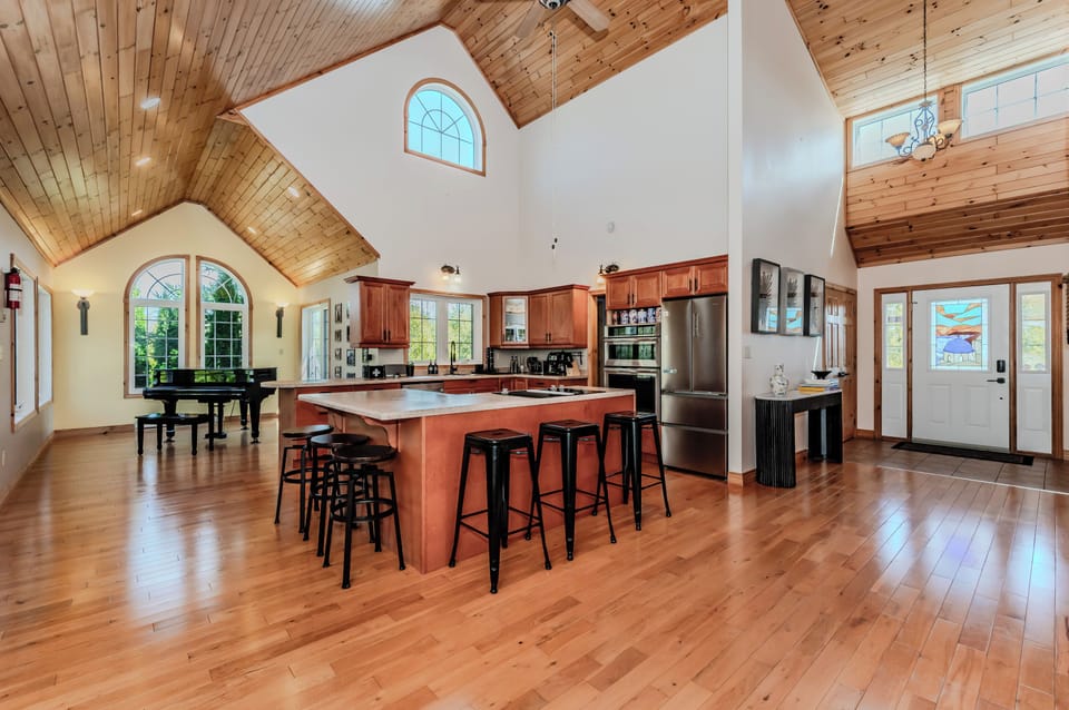 Unwind in this open-concept great room featuring a chef's kitchen, cathedral ceilings, and rustic charm—perfect for group gatherings, culinary adventures, or cozy evenings in a peaceful cottage retreat.