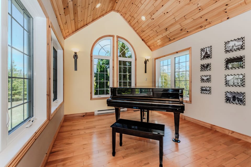 Relax in this sun-drenched music nook with a grand piano and panoramic views—ideal for morning coffee, reading, or letting creativity flow during your vacation getaway.