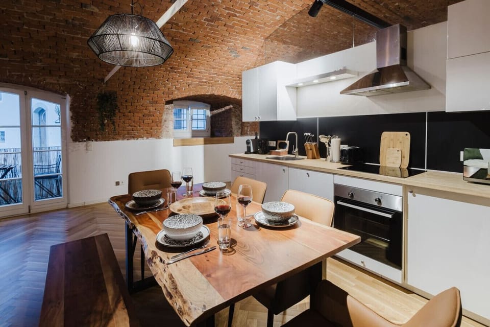 Elegant dining space beneath authentic brick arches, opening to a sunny balcony.
